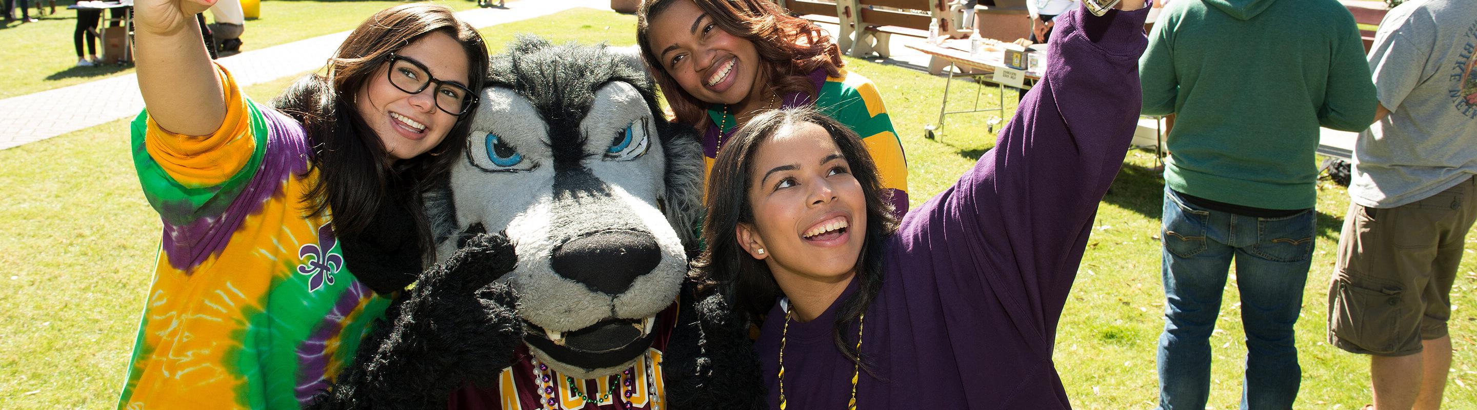 Group of students taking photo with mascot Havoc